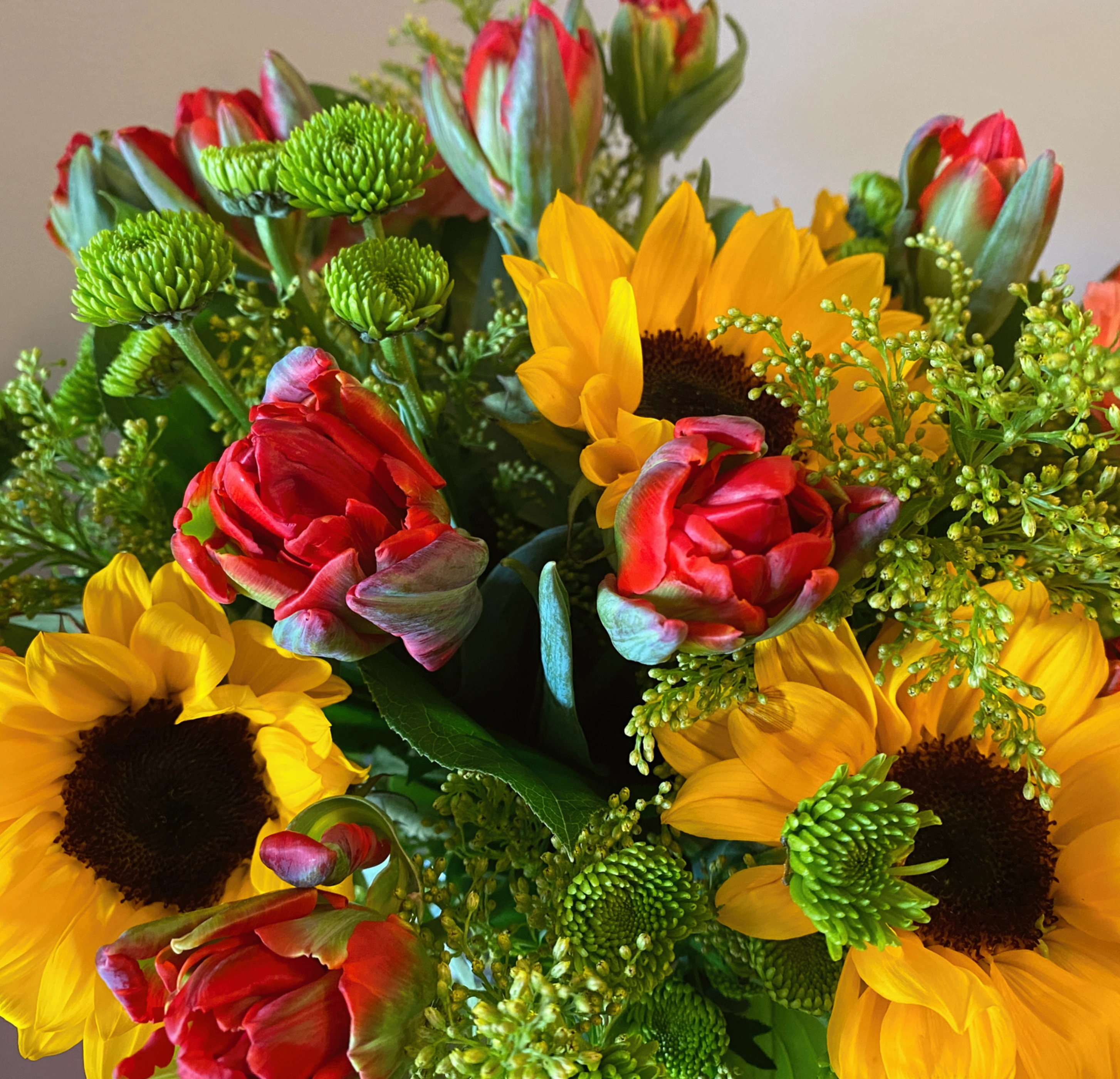 Bright sunflowers and red roses in a vibrant bouquet.