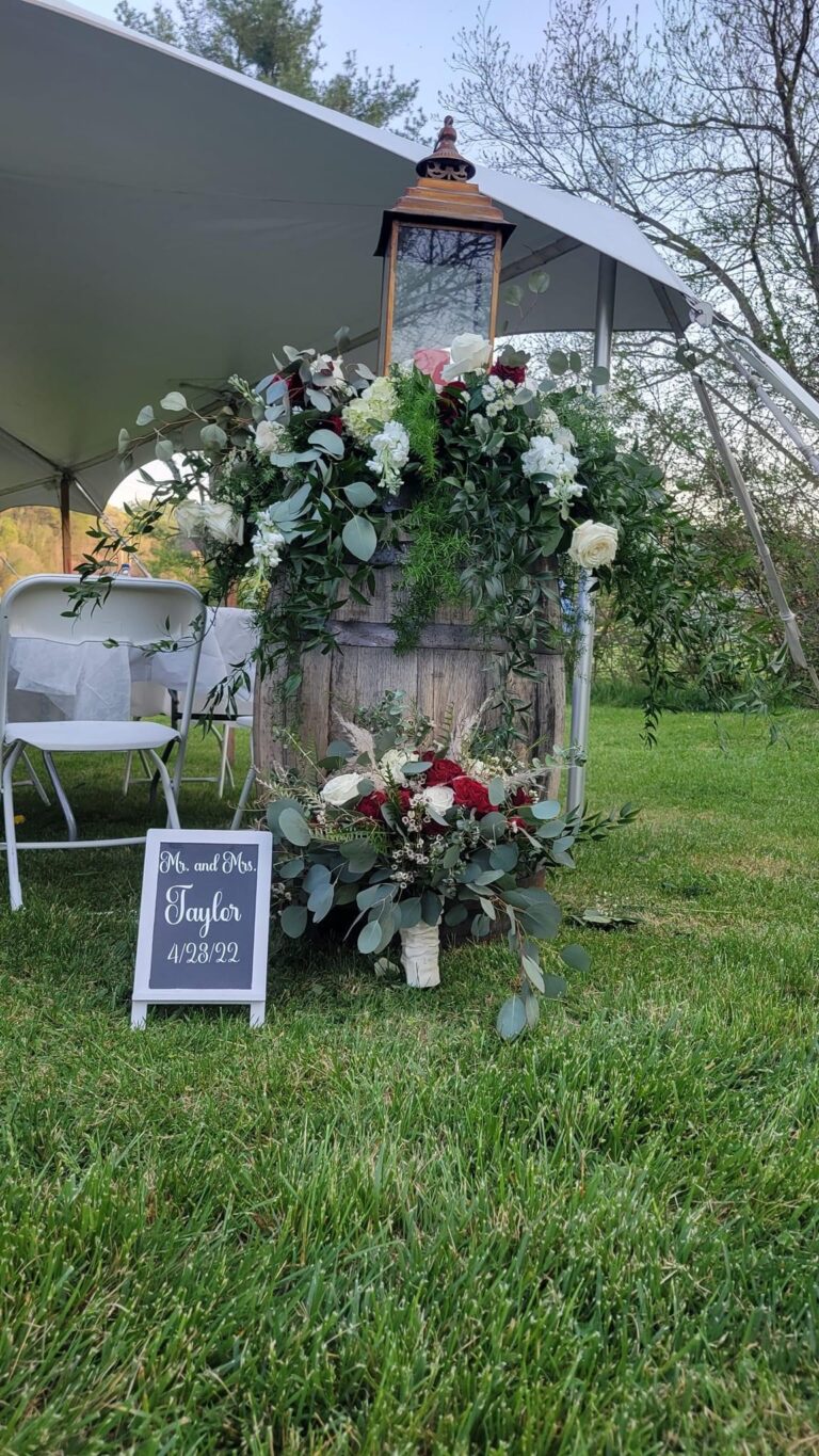 Elegant floral arch and chairs set up for an outdoor wedding ceremony.
