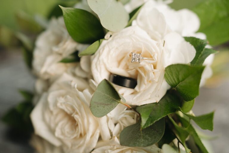 Close-up of white roses with green leaves.