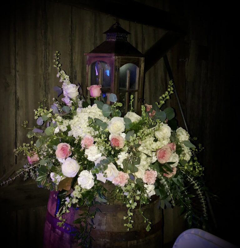 Elegant floral arrangement with white and pink roses under soft lighting.