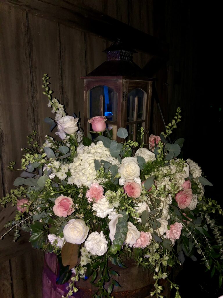 Elegant bouquet with pink and white flowers in a lantern-lit setting.