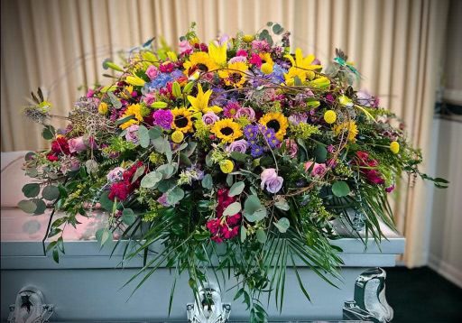 A vibrant floral arrangement with sunflowers and assorted colorful flowers.