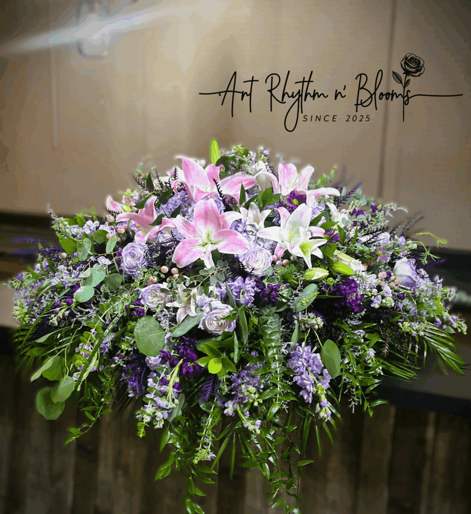 Elegant floral arrangement with pink lilies and purple blooms.