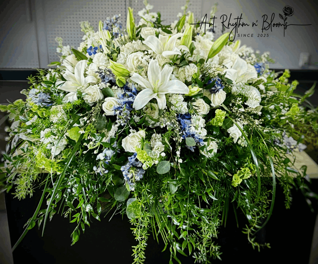 A lush floral arrangement with white lilies and blue accents.