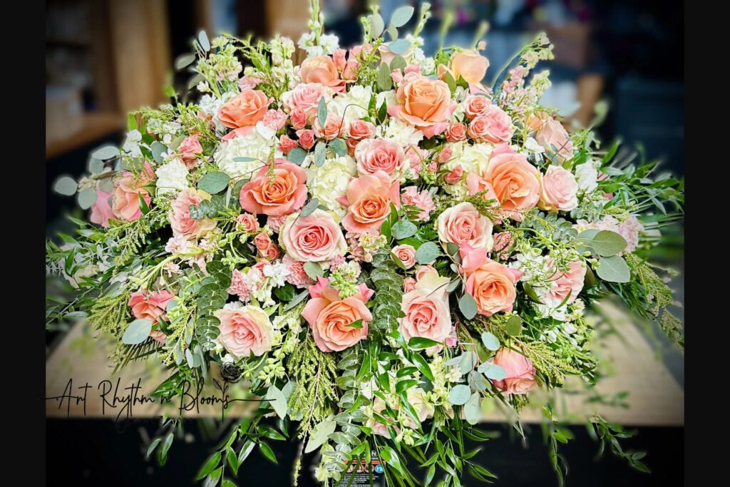 A beautiful bouquet of peach and white roses with greenery.